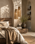Cozy bedroom with wooden headboard, textured walls, and hanging rattan lamps.