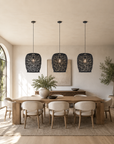 Dining room with wooden table, chairs, and three black pendant lights.