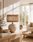 Living room with a lamp on a wooden cabinet, books, and decorative items.