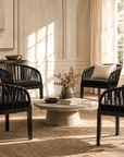 Living room with black wicker chairs and a stone coffee table.