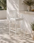 White outdoor chair on a patio with sunlight casting shadows
