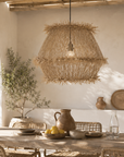 Woven pendant light hanging above a dining table with rustic decor.