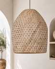 Woven pendant light hanging in a room with neutral decor