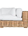 Natural wicker corner chair with thick white cushions, showcasing a coastal-inspired design perfect for indoor and outdoor settings