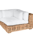 Natural wicker corner chair with thick white cushions, showcasing a coastal-inspired design perfect for indoor and outdoor settings
