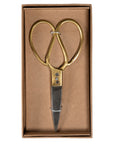 A pair of vintage-style scissors with brass handles and stainless steel blades, elegantly presented in a minimalist cardboard gift box