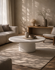 Ayanda coffee table in white hydro dipped finish with round top and pedestal base styled in a sunlit living room with soft neutral furnishings.