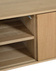 Bajo Entertainment Unit in natural oak with four flat-panel doors and a low-profile design.