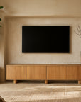 Bajo Sideboard crafted from natural oak styled in a modern living room with neutral tones, featuring a floating design beneath a wall-mounted TV and ceramic vase