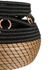 Black and natural woven basket with circular accents, ideal for decorative storage and adding texture to interior spaces.