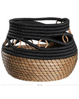 Black and natural woven basket with circular accents, ideal for decorative storage and adding texture to interior spaces.