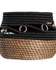 Black and natural woven basket with circular accents, ideal for decorative storage and adding texture to interior spaces.