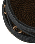 Black and natural woven basket with circular accents, ideal for decorative storage and adding texture to interior spaces.