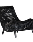 A sculptural black rattan lounge chair with a curved, low-profile silhouette and sleek wooden legs. The woven design adds texture, while the deep seat and ergonomic shape offer comfort and relaxation