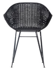 Black rattan dining chair with curved back and slim metal legs, perfect for modern and stylish dining settings