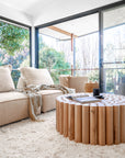 Caribbean Coffee Table styled with books and ceramic décor, paired with the Jimmy Sofa in a light-filled neutral living room with a textured rug and garden views