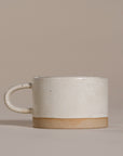 A beautifully handcrafted ceramic coffee mug and matching cup, featuring a minimalist stoneware design with a natural speckled glaze and raw clay base. Perfect for enjoying your morning coffee or tea in a timeless, artisanal style