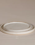 A set of handcrafted ceramic dinner plates in a soft speckled stoneware finish, featuring a minimalist design with a slightly raised rim. Perfect for modern, organic-style dining