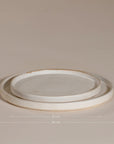 A set of handcrafted ceramic dinner plates in a soft speckled stoneware finish, featuring a minimalist design with a slightly raised rim. Perfect for modern, organic-style dining