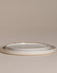 A set of handcrafted ceramic dinner plates in a soft speckled stoneware finish, featuring a minimalist design with a slightly raised rim. Perfect for modern, organic-style dining