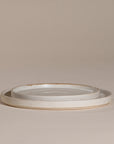 A set of handcrafted ceramic dinner plates in a soft speckled stoneware finish, featuring a minimalist design with a slightly raised rim. Perfect for modern, organic-style dining
