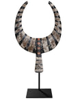 A striking decorative tribal horn sculpture with bold black and natural tones, mounted on a sleek black stand, adding an artisanal touch to modern interiors.