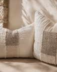 Dune rectangle and square cushions styled on a built in bench, showcasing soft woven textures and warm neutral tones in a relaxed Mediterranean inspired setting.