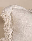 A beautifully textured handwoven linen cushion cover in a soft natural hue, featuring delicate fringe details for a relaxed, organic look. Ideal for layering on sofas or beds