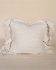 A beautifully textured handwoven linen cushion cover in a soft natural hue, featuring delicate fringe details for a relaxed, organic look. Ideal for layering on sofas or beds