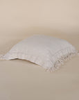 A beautifully textured handwoven linen cushion cover in a soft natural hue, featuring delicate fringe details for a relaxed, organic look. Ideal for layering on sofas or beds
