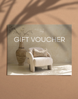 Kulala Living gift voucher featuring a neutral-toned armchair with a textured cushion, a rustic clay vase, and soft natural light, creating an elegant and timeless gifting option