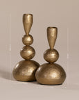 Set of gold sculptural candlesticks with a hammered brass finish, featuring organic stacked spheres for a unique, artisanal look