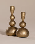 Set of gold sculptural candlesticks with a hammered brass finish, featuring organic stacked spheres for a unique, artisanal look