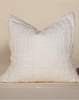 Soft off-white linen cushion with a hand-stitched patchwork design, adding texture and warmth to any living space