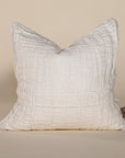 Soft off-white linen cushion with a hand-stitched patchwork design, adding texture and warmth to any living space