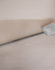 A handcrafted metal spatula from KULALA Living, featuring a perforated stainless steel paddle and a long black iron handle for effortless pizza baking and serving
