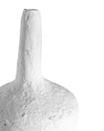 A handcrafted white paper mache vase with a raw, textured finish and an elongated silhouette. A striking sculptural piece perfect for minimalist or contemporary interiors