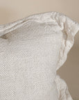 A soft, handwoven linen cushion cover in a natural off-white hue, featuring a relaxed, textured finish. Perfect for adding an organic touch to any living space