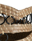 A set of handwoven natural baskets featuring intricate black metal ring detailing and striped accents. Crafted from organic fibres, these versatile storage baskets add a touch of artisanal craftsmanship to any space