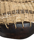 A unique handwoven rattan decorative basket with an open-weave design and a dark wooden base. A statement piece that adds texture and organic warmth to any interior