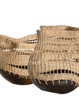 A unique handwoven rattan decorative basket with an open-weave design and a dark wooden base. A statement piece that adds texture and organic warmth to any interior