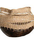 A unique handwoven rattan decorative basket with an open-weave design and a dark wooden base. A statement piece that adds texture and organic warmth to any interior
