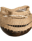 A unique handwoven rattan decorative basket with an open-weave design and a dark wooden base. A statement piece that adds texture and organic warmth to any interior