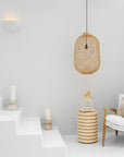 Kulala Living handwoven rattan pendant light styled in a minimalist white space, paired with natural wood furniture and soft textiles for a relaxed, coastal aesthetic