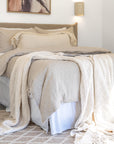 Styled with soft neutral bedding and a chunky knit throw, creating a warm and inviting bedroom atmosphere
