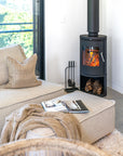 Cosy corner featuring the Jimmy Sofa and ottoman styled with a chunky knit throw beside a crackling wood fire, creating a warm and inviting winter retreat