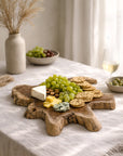 Koro serving board in teak styled with cheese, grapes and crackers on a soft neutral entertaining table setting.