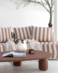Laguna sofa in cinnabar clay stripe paired with Lantara coffee table creating a warm relaxed outdoor setting with soft earthy tones.