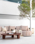 Laguna sofa in cinnabar clay stripe styled with Lantara coffee table and side table creating a warm earthy outdoor living setting.