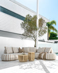 Laguna sofa in sand stripe fabric paired with Berber coffee table and side table in driftstone creating a relaxed coastal outdoor setting.